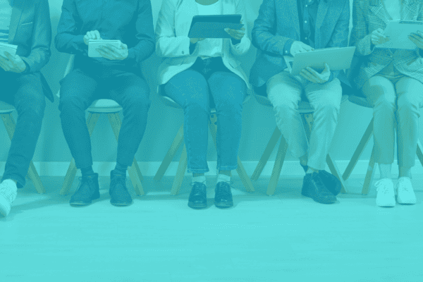 Diverse team of professionals sitting with tablets and laptops.