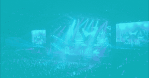 Concert stage with vibrant lighting and large screens at a live event.