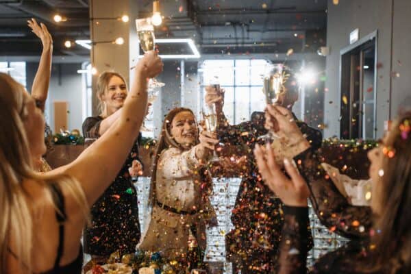 Team celebrating with champagne and confetti at BlueWave Resource Partners event.
