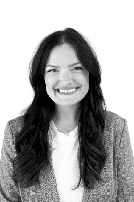 Smiling woman with long dark hair in professional attire.