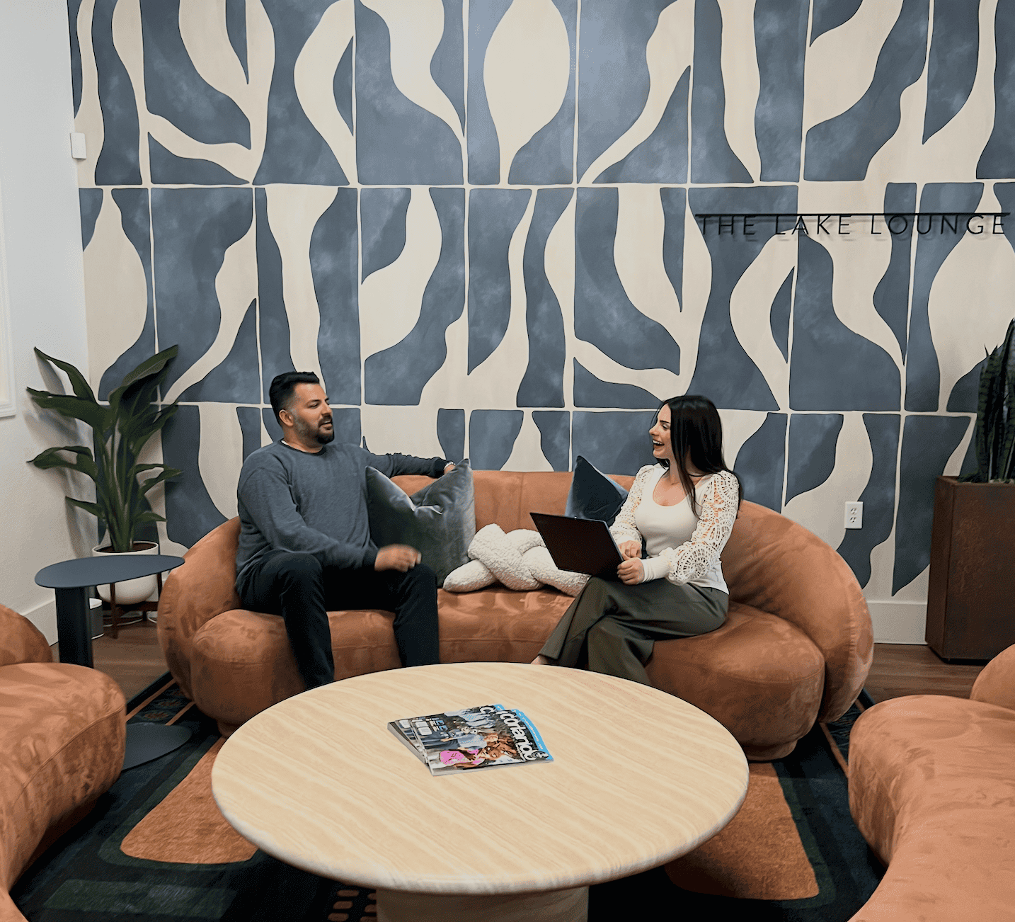 Business professionals discussing in a modern lounge setting.
