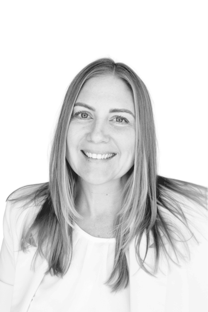 Professional portrait of a smiling woman with long hair in black and white.