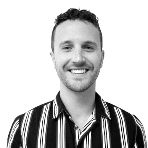 Portrait of a smiling man with curly hair in a striped shirt.