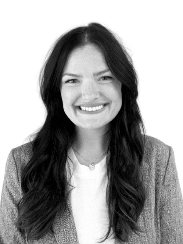 Smiling woman with long dark hair in professional attire.