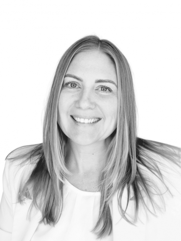 Professional portrait of a smiling woman with long hair in black and white.